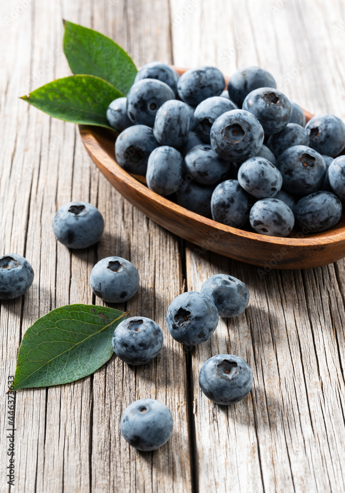 Brubery and blueberry leaves on an old wooden board.