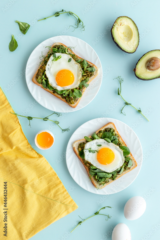 Toasts with eggs and avocado cream and spinach. Top view