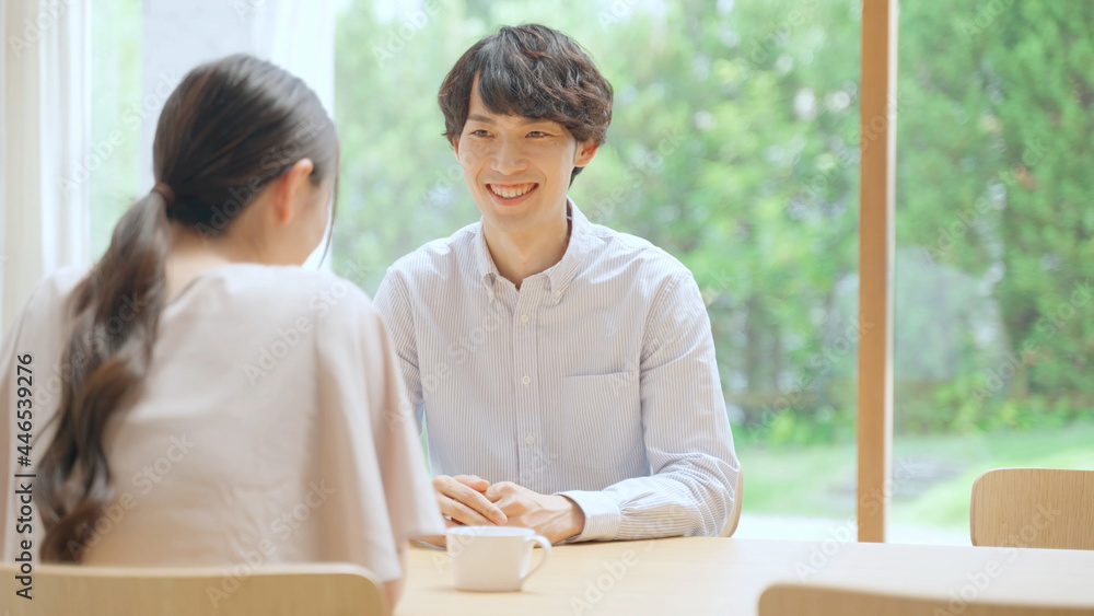 室内で会話をする若いカップル