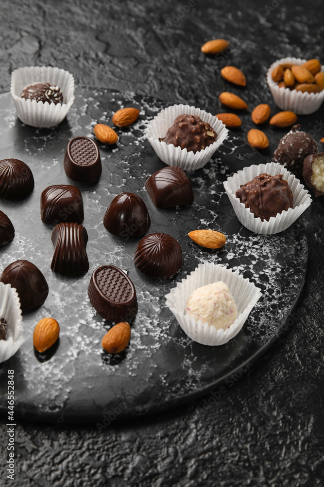 Sweet chocolate candies with nuts on dark background