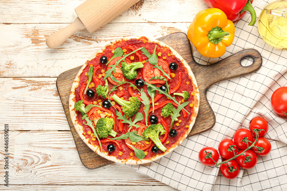 Board with tasty vegetarian pizza on light wooden background