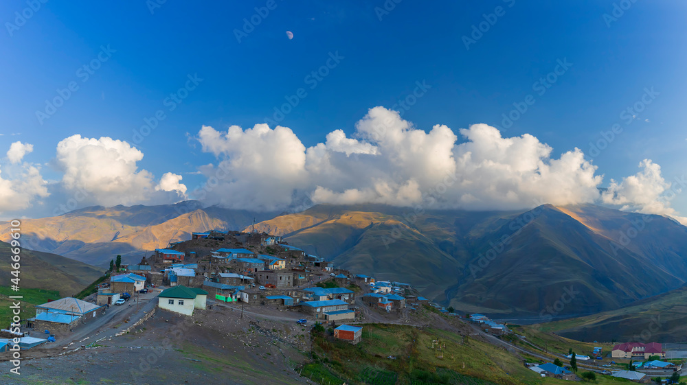 日落时美丽的云朵背景下的高山村庄Khinalig