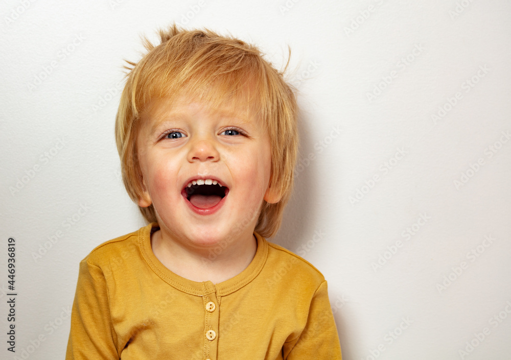 Close happy blond little boy portrait laughing