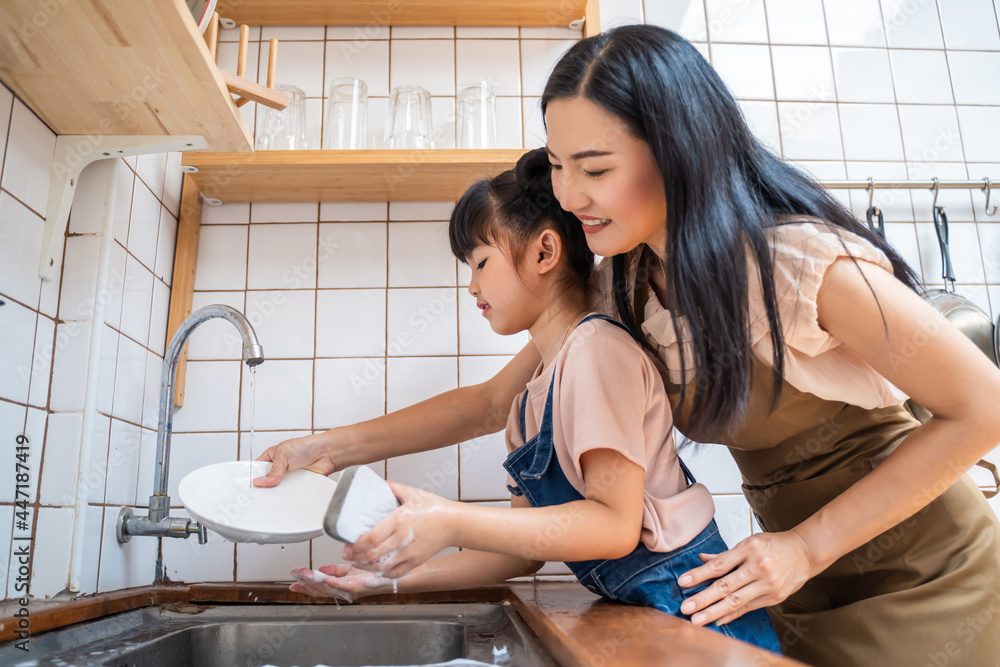 爱亚洲的妈妈教学前班的小女孩在家洗碗。