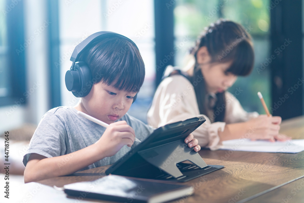 亚洲幼儿在家客厅的桌子上自学