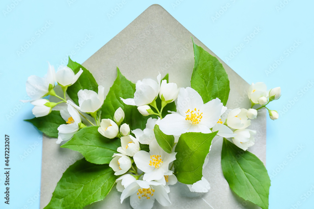 Envelope with beautiful jasmine flowers on color background, closeup