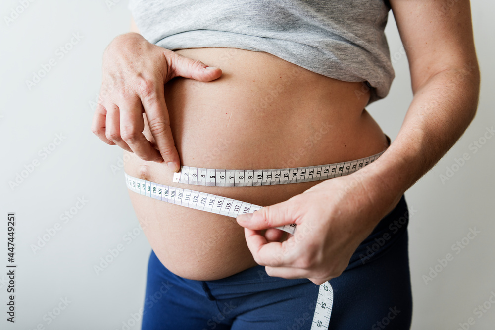 Pregnant woman measuring her bump