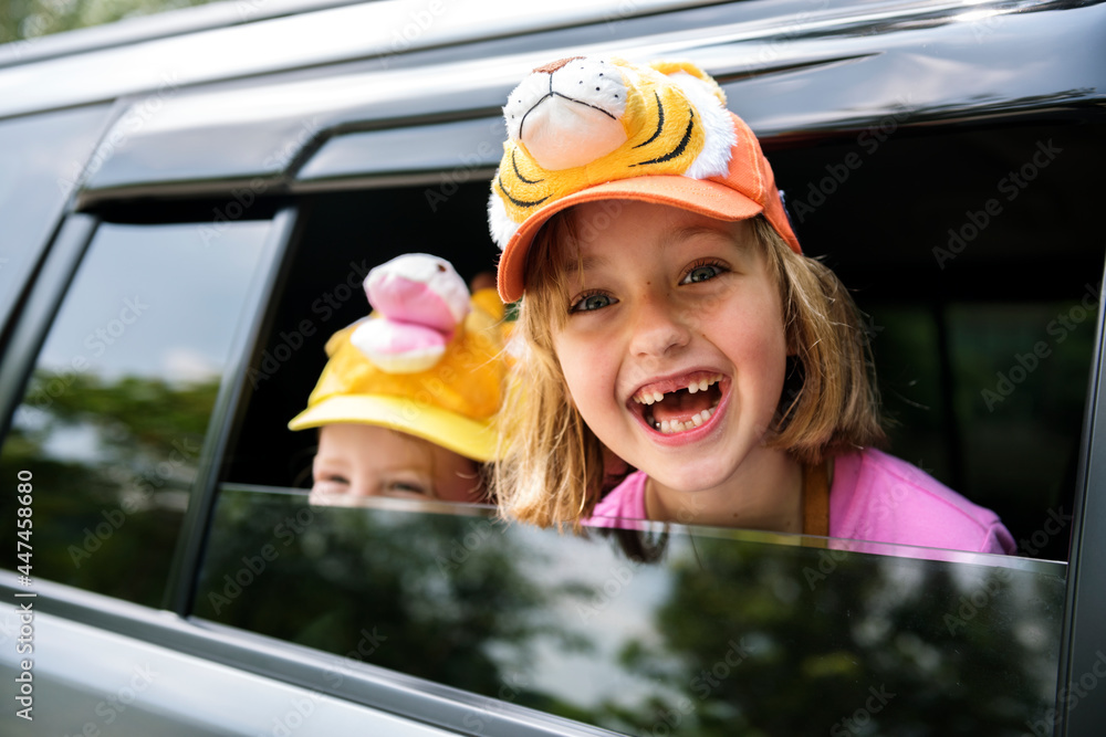 Caucasian girls smiling head out of the car