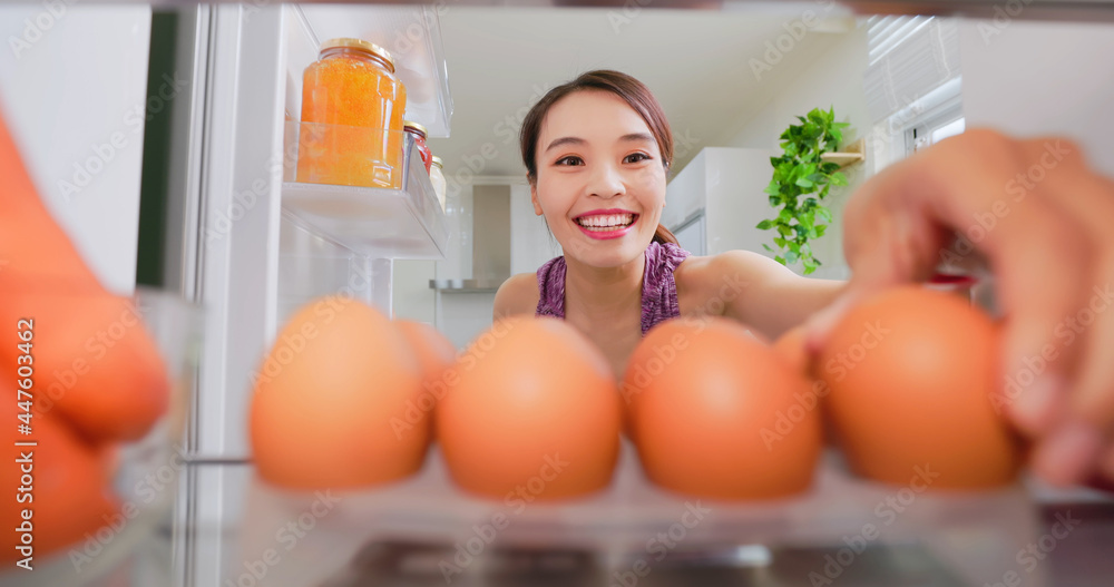 woman takes eggs from refrigerator