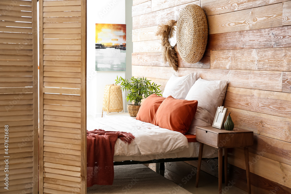 Interior of stylish bedroom with folding screen