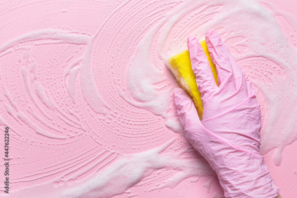 Woman with sponge cleaning color surface