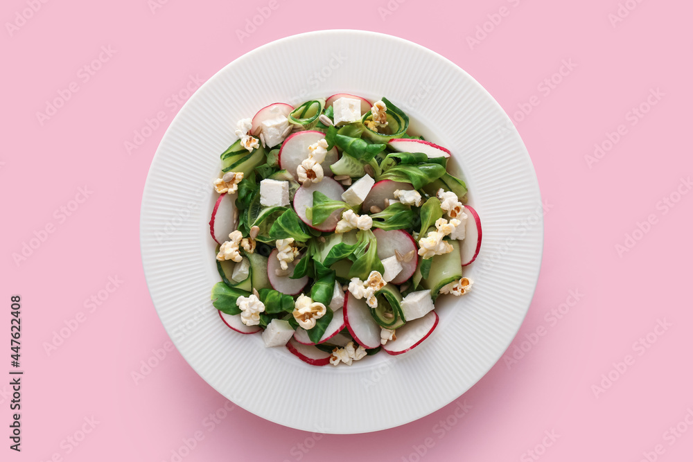 Plate with tasty popcorn salad on color background