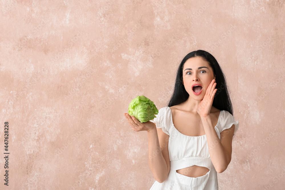 Young woman with fresh cabbage on color background