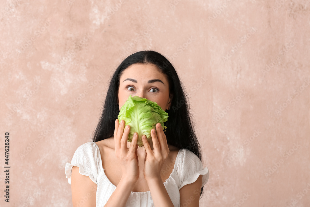 Young woman with fresh cabbage on color background