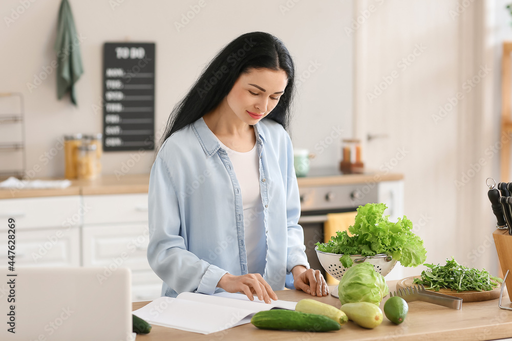 年轻女子在厨房里读菜谱