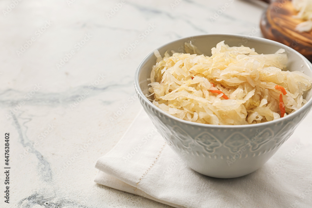 Bowl with tasty sauerkraut on light background