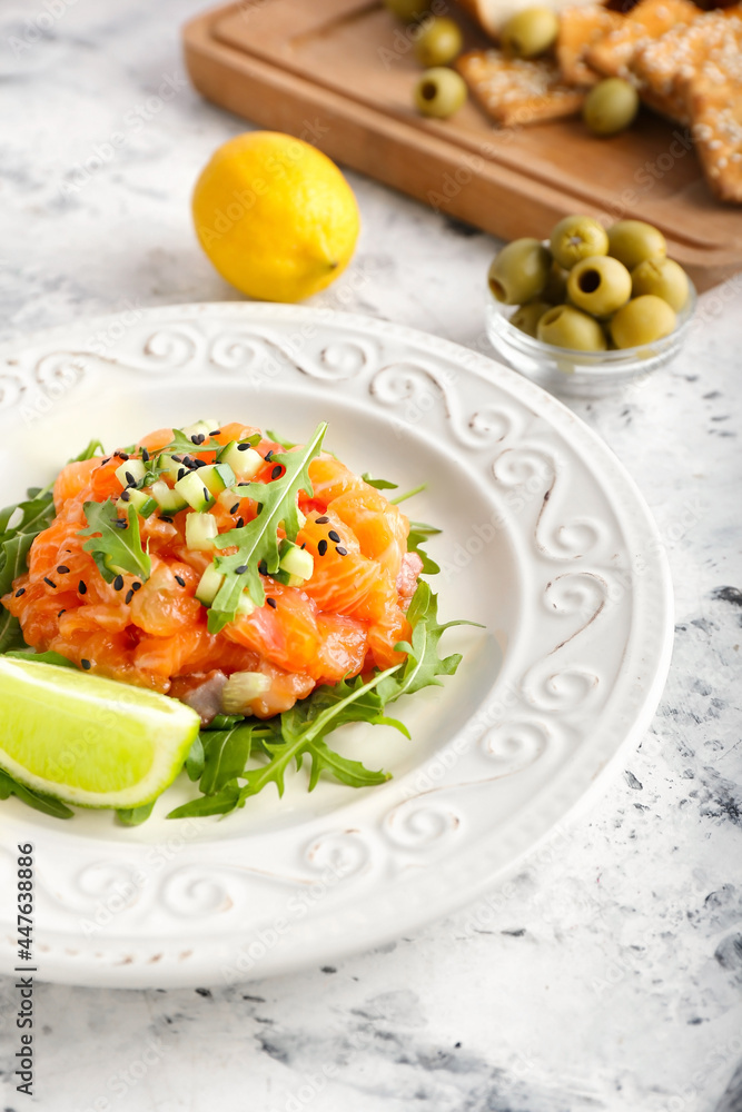 Delicious salmon tartar on marble table, closeup