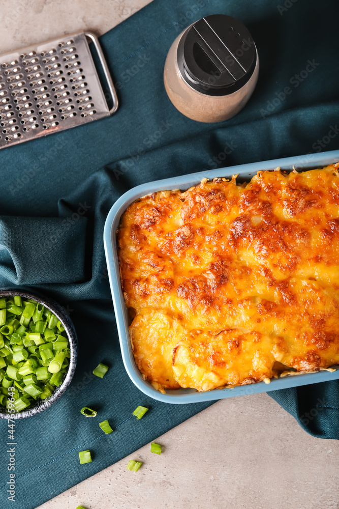 Baking dish with tasty potato casserole on light background