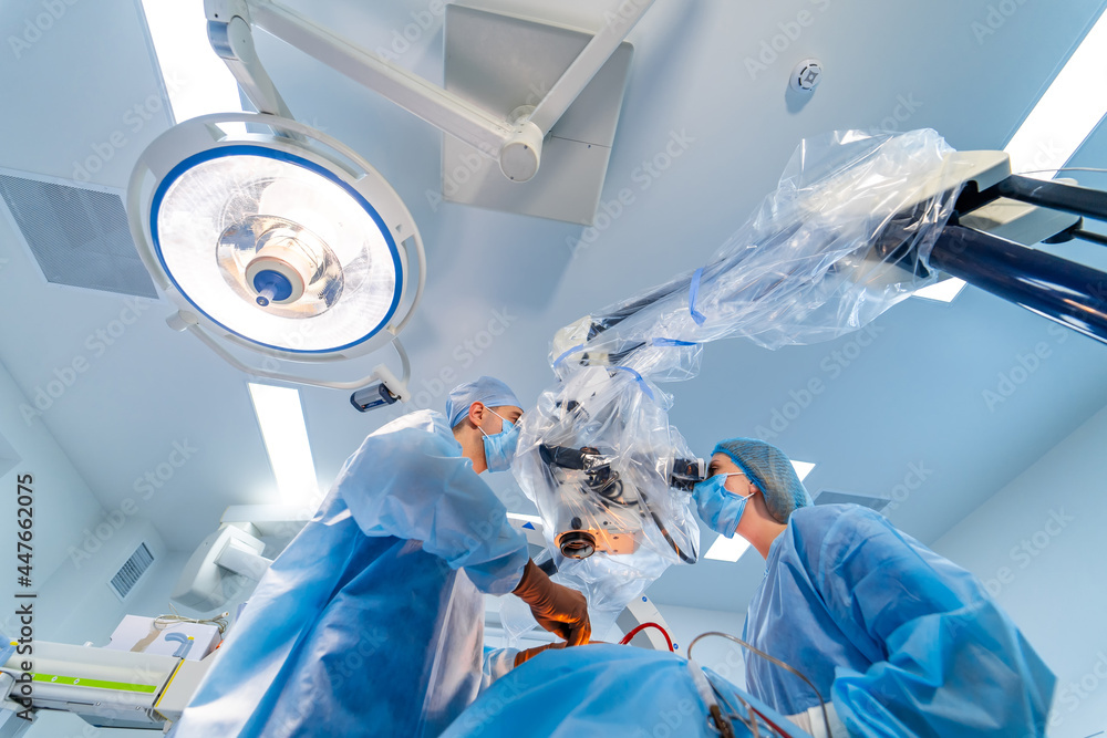 Low angle view of the attentive medical workers operating their patient. Nervous surgeons discussing