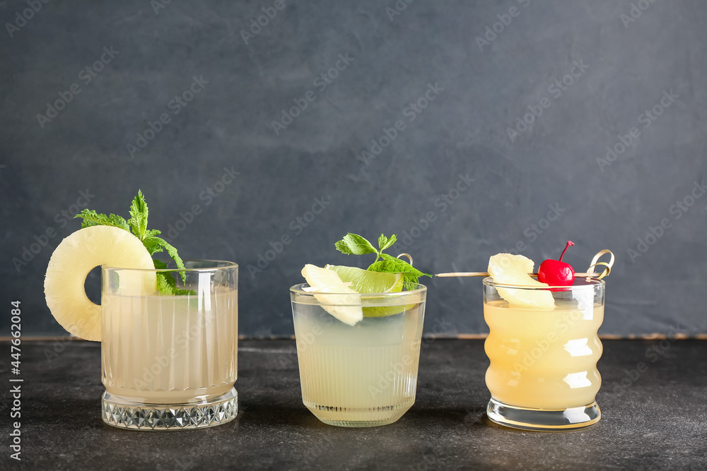 Glasses of delicious mai tai cocktail on dark background