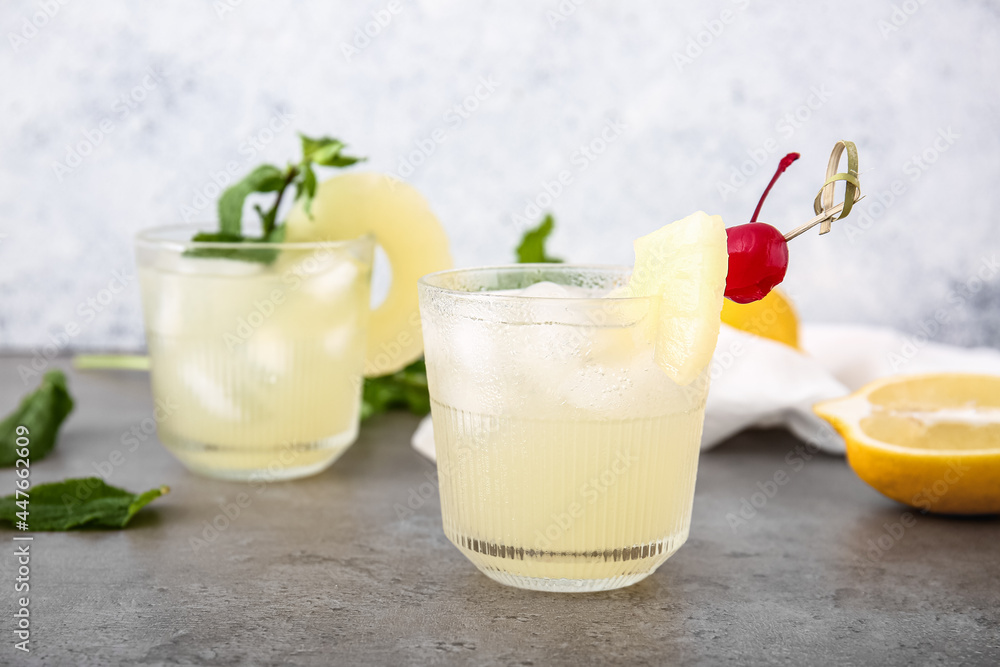 Glasses of delicious mai tai cocktail on grey background