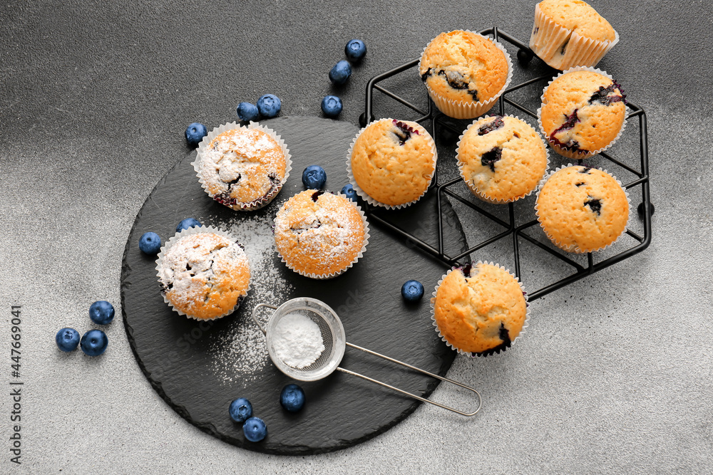 Composition with tasty blueberry muffins and berries on black and white background