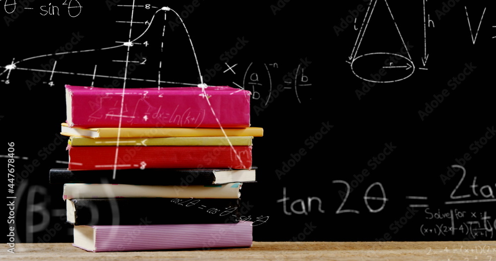 Mathematical equations floating against stack of books on wooden surface