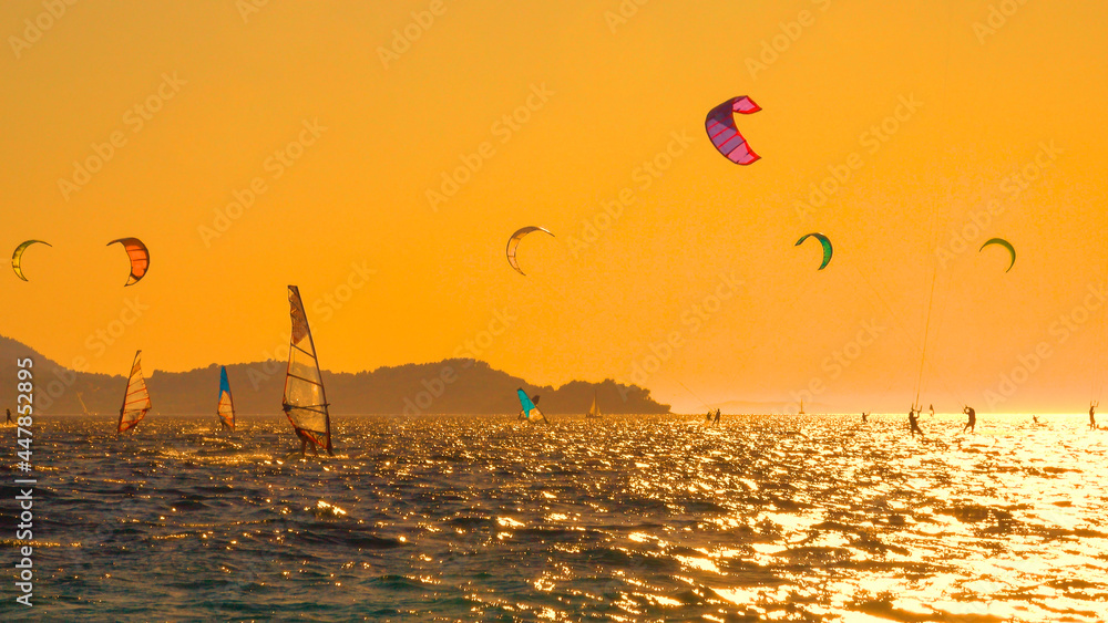 在一个阳光明媚的夏夜，精力充沛的游客在克罗地亚沿海冲浪。