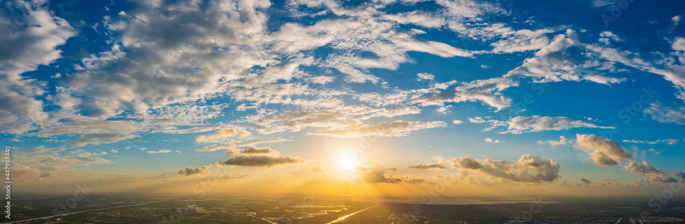 Aerial view of beautiful clouds and sun at sunset.