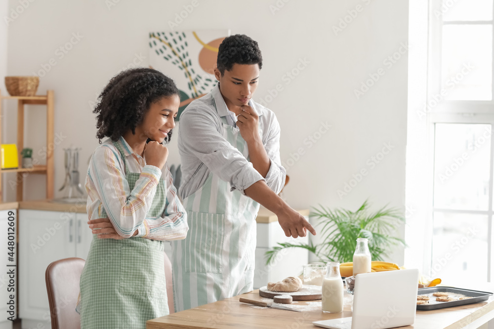 African-American brother and sister making cookies in kitchen