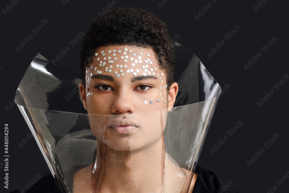 Creative portrait of handsome African-American guy on dark background