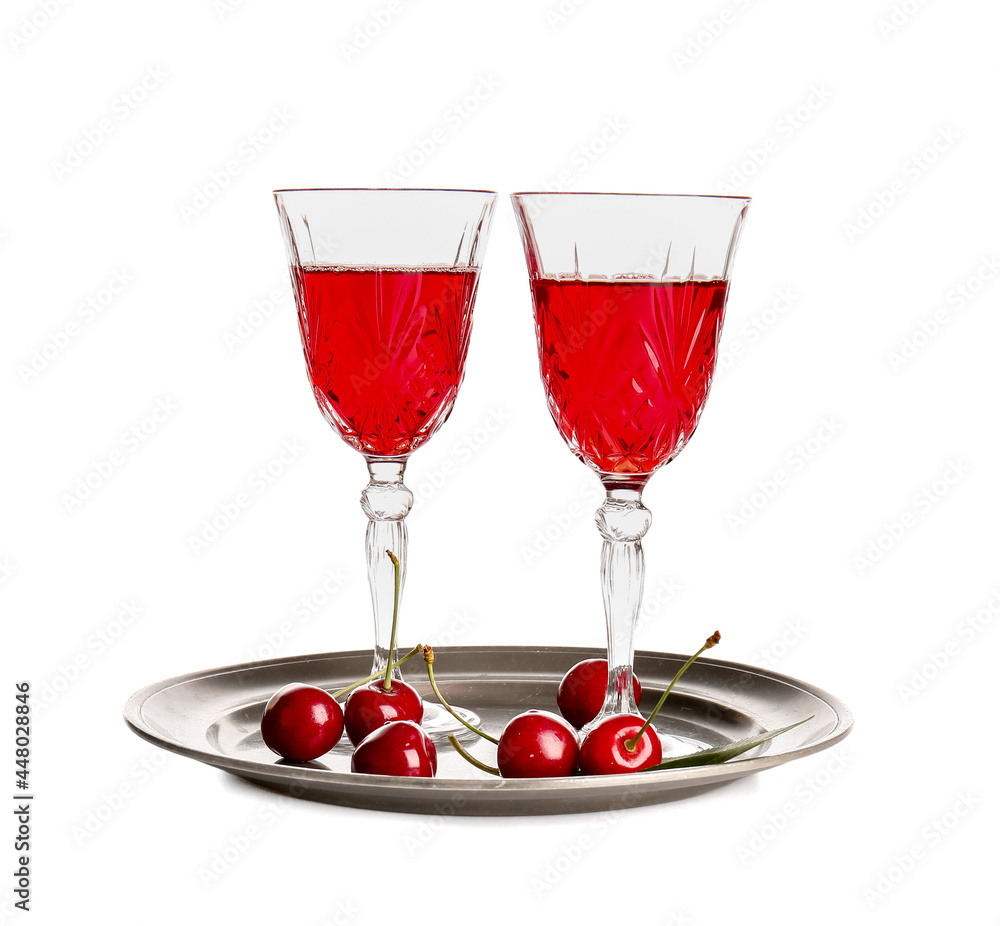 Plate with glasses of sweet cherry wine on white background