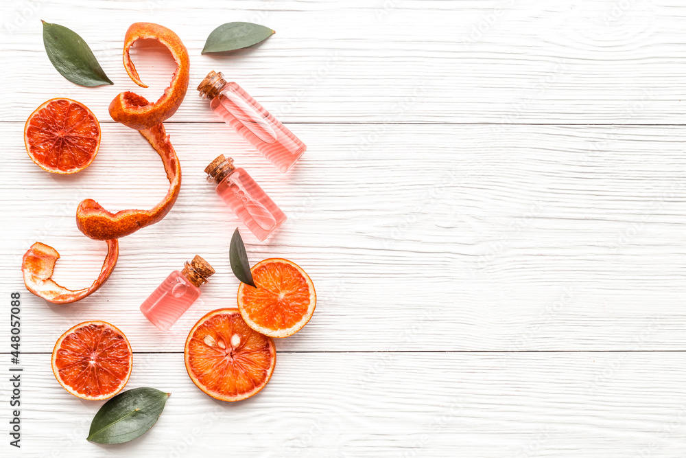 Grapefruit fragrance essential oil in bottles with fresh fruits. Top view