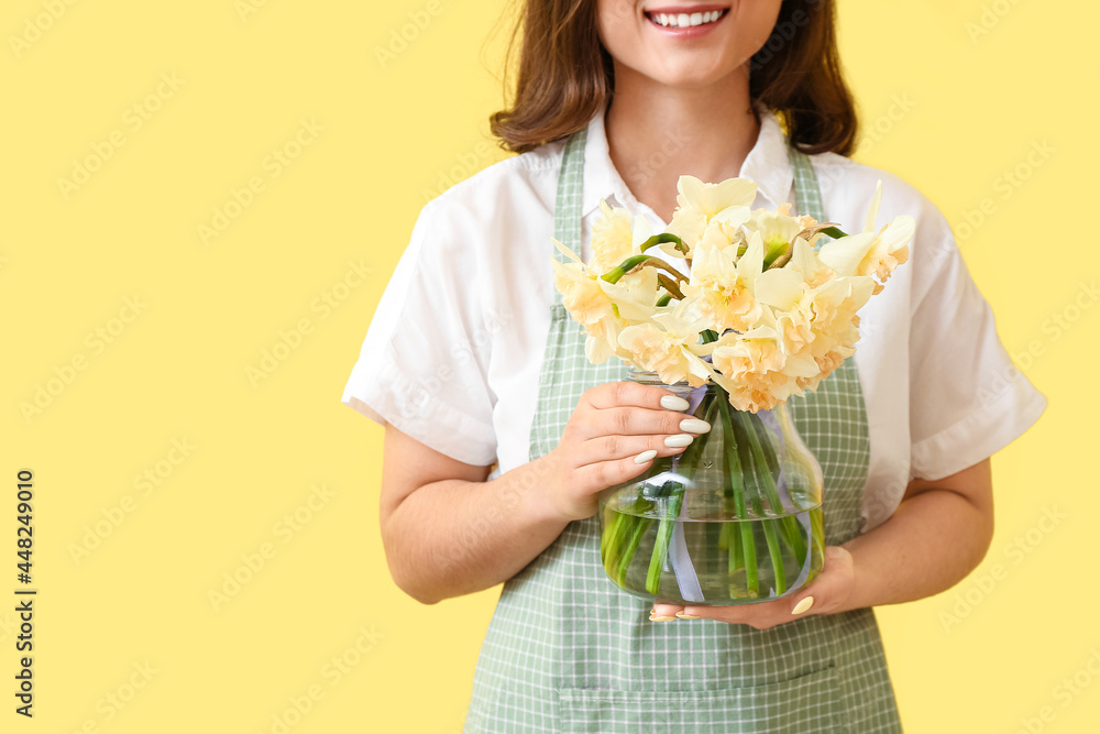 彩色背景上有一束美丽的水仙花的女花商