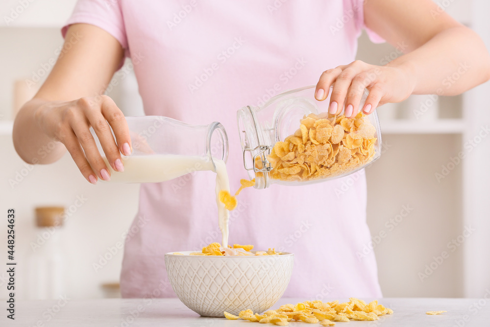 女人在厨房用玉米片准备美味的早餐