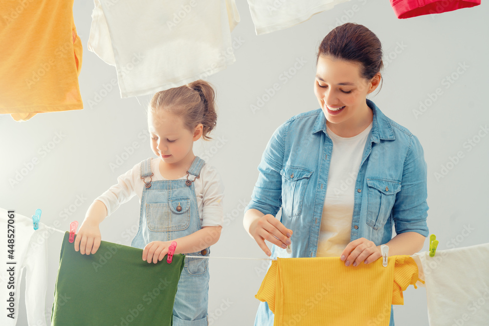 妇女和女孩把衣服挂在绳子上