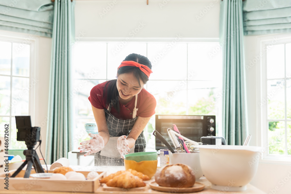 女人在餐厅厨房里用面粉拍面包师的手。