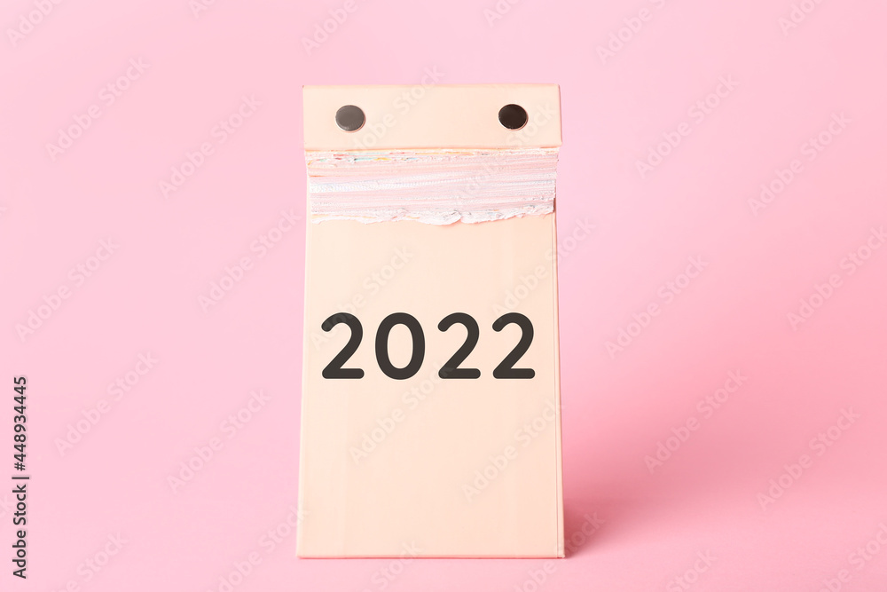 年底撕下日历，2022年为彩色背景。新年目标的概念