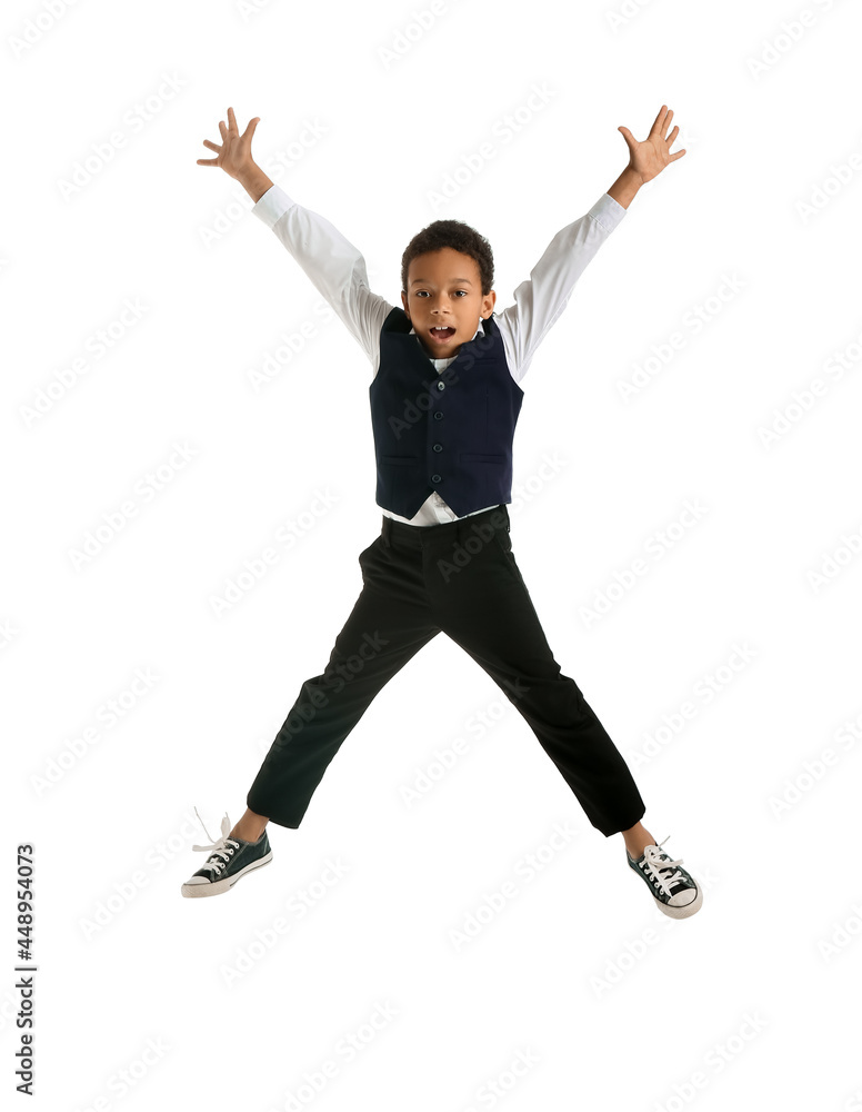 Jumping little African-American schoolboy on white background