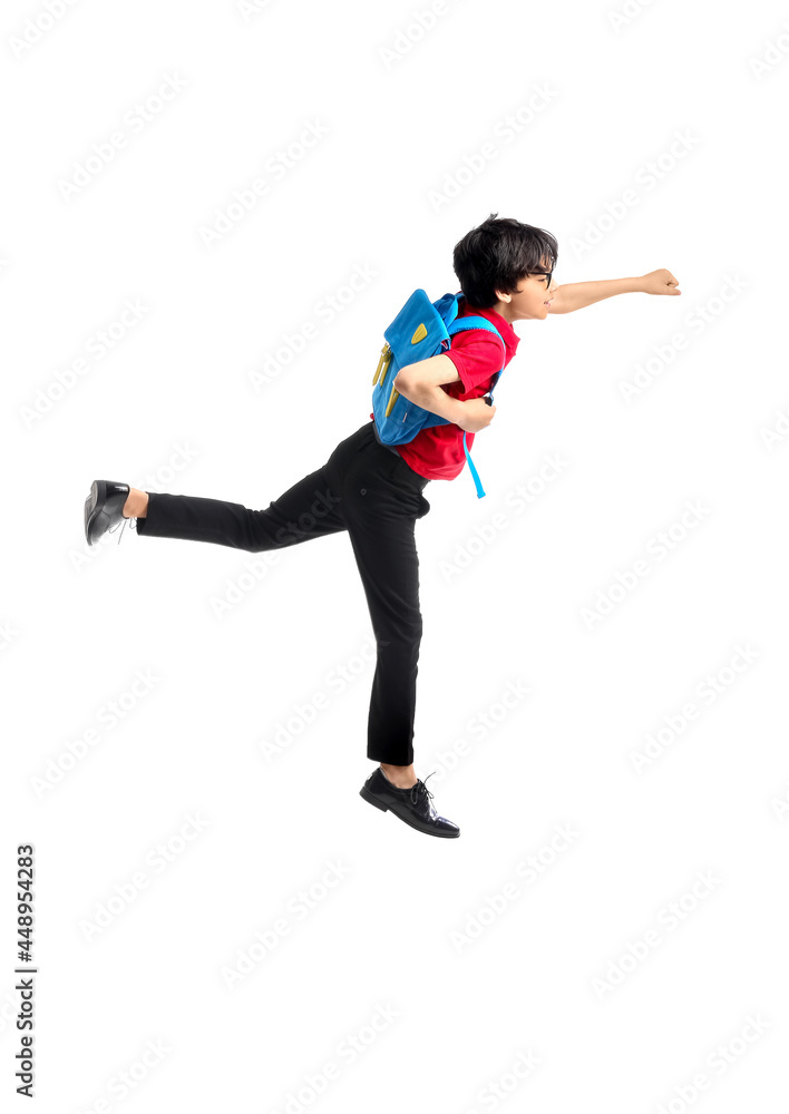 Jumping little schoolboy on white background