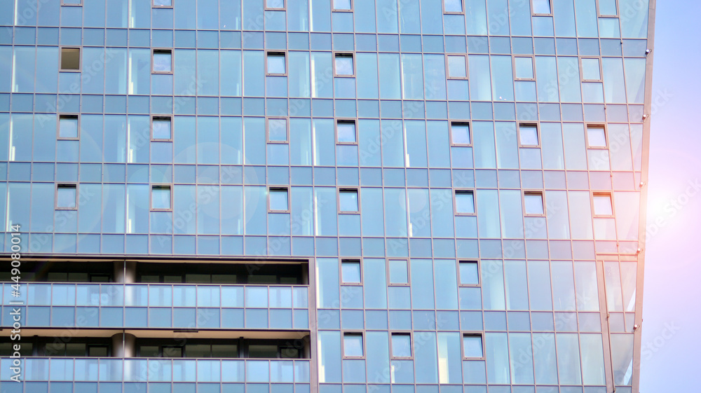 Futuristic façade of a modern office building clad in glass. Glass cladding panels and windows of mo