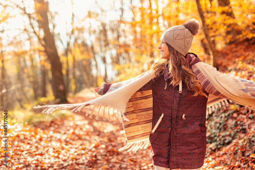 Woman spinning in circles while walking through forest in autumn