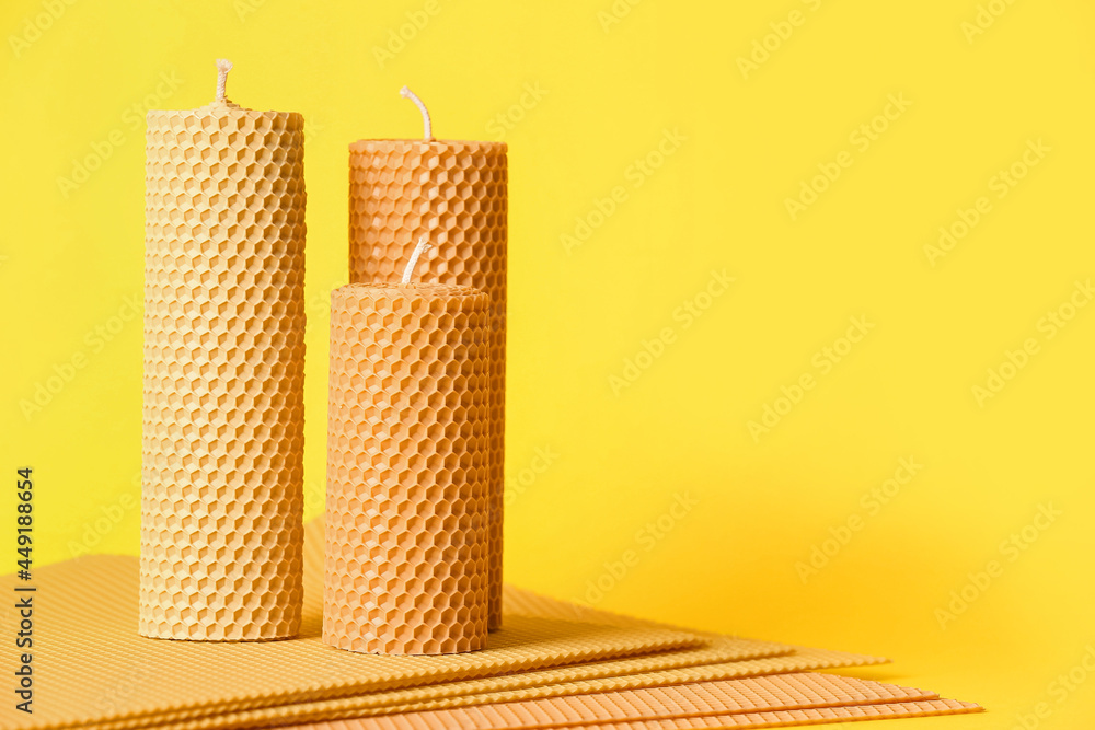 Handmade wax candles on color background