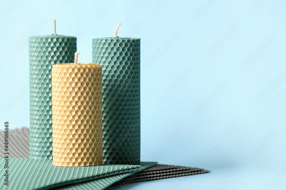 Handmade wax candles on color background