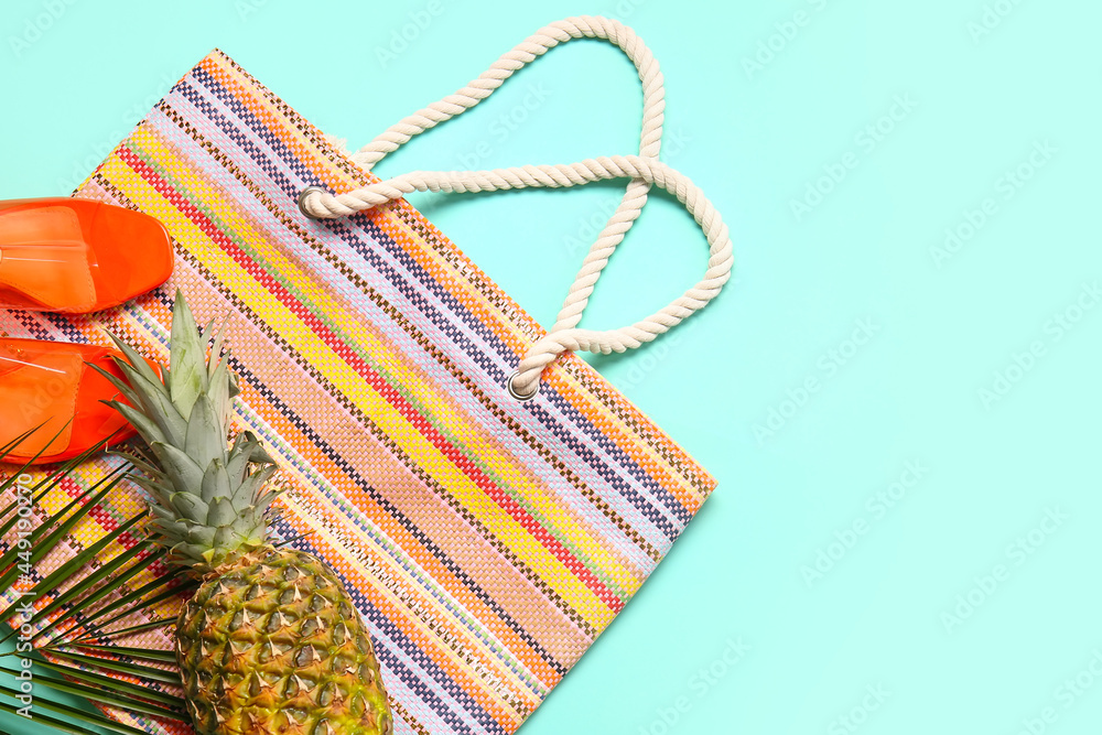 Stylish shoes, bag, pineapple and palm leaf on color background, closeup