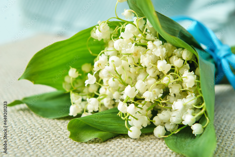 Beautiful lily-of-the-valley flowers on chair, closeup