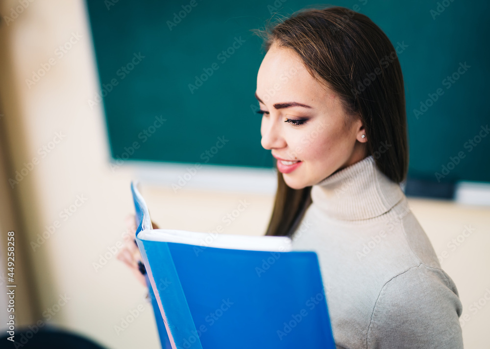 教室里美丽的学校老师。绿色w上微笑的女学生或女老师肖像