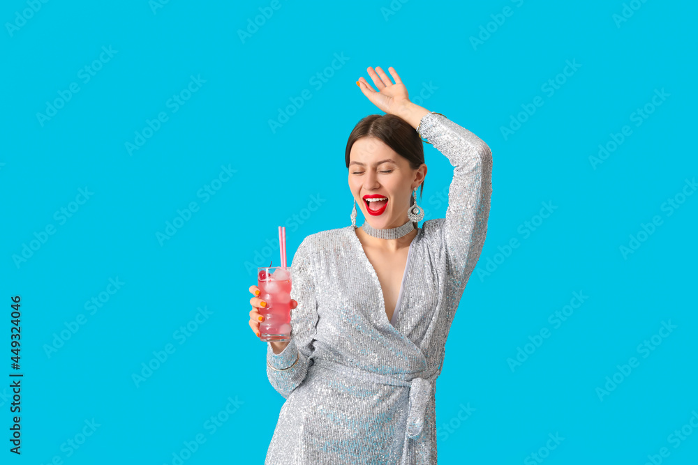 Beautiful young woman with cocktail on color background