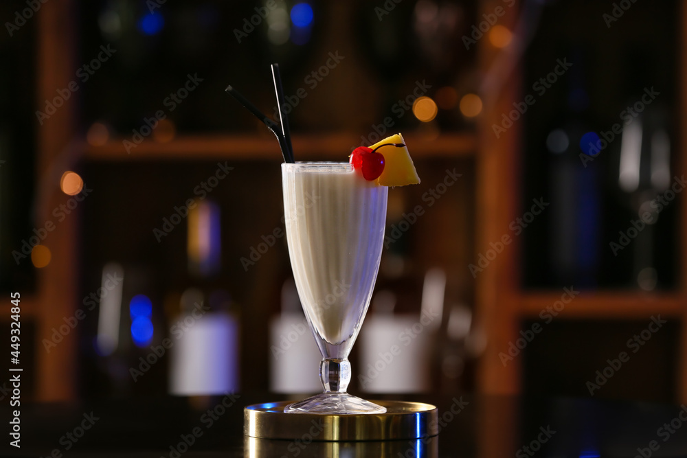 Glass with tasty Pina Colada cocktail on table in bar