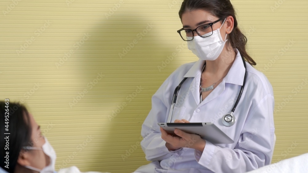 Doctor wearing face mask proficiently talks with patient at hospital ward . Healthcare and medical s